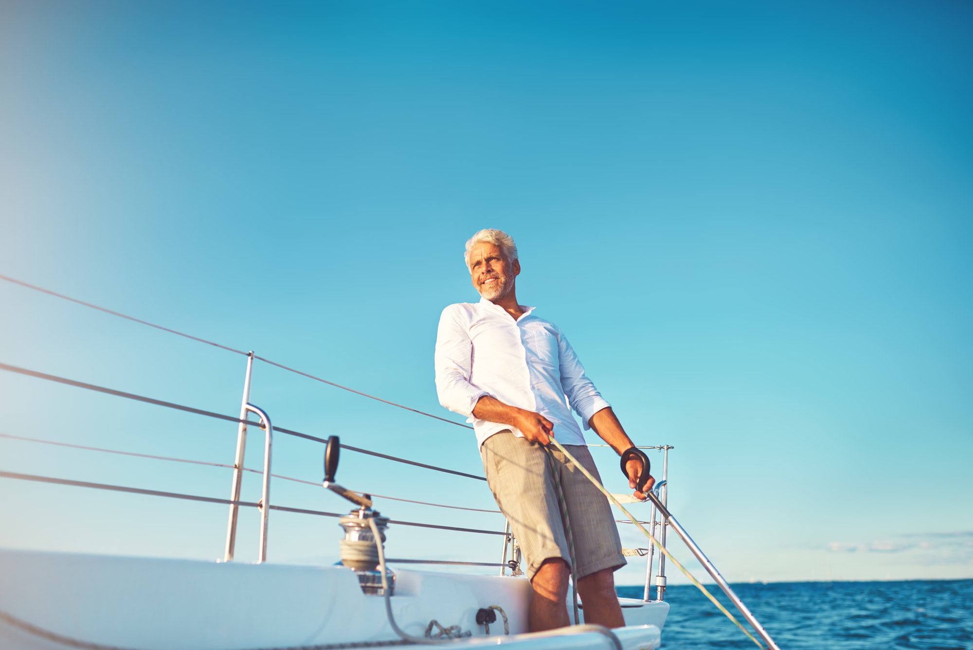 Smiling mature man enjoying a day sailing on the ocean