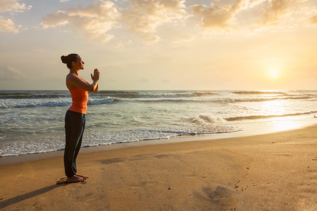 Woman doing yoga on beach